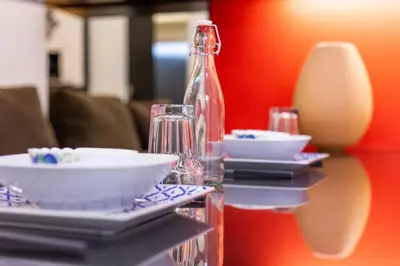 a table with plates and glasses and a glass bottle at Unique Design House, 2BR House - Near Ipoh Local Foodies in Ipoh