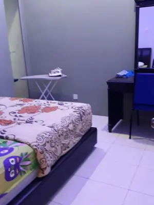 a bedroom with a bed and a table with a phone at Camlodge apartments in Tanah Rata