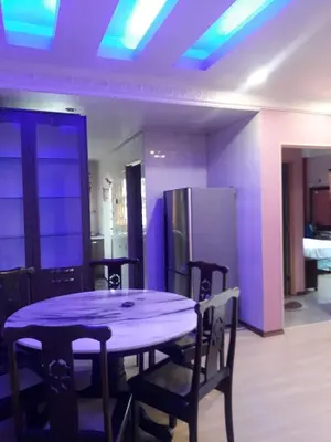 a dining room table with chairs and a purple ceiling at Camlodge apartments in Tanah Rata