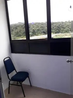 a blue chair sitting in front of a window at Camlodge apartments in Tanah Rata