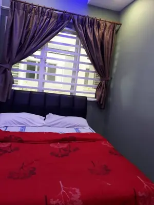 a bedroom with a red bed with a window at Camlodge apartments in Tanah Rata