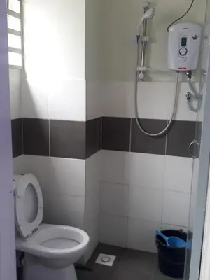 a small bathroom with a toilet and a shower at Camlodge apartments in Tanah Rata
