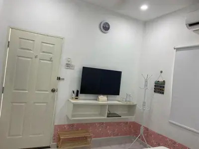 a living room with a television on a white wall at Sammy Hoomestay Ipoh in Ipoh