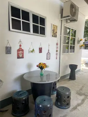 a room with a table and stools with a vase of flowers at Sammy Hoomestay Ipoh in Ipoh