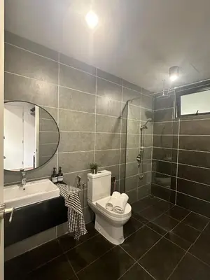 a bathroom with a toilet and a sink and a shower at Sunway Onsen Suites in Tambun