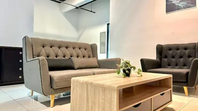 a living room with a couch and a coffee table at 2BR Lively City View Family Suite#Airport in Bayan Lepas