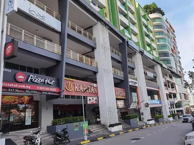 a building on a street with motorcycles parked in front at 2BR Airport Panoramic View Family Suite in Bayan Lepas