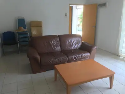 a brown leather couch and a coffee table in a living room at Batu Kawan Home in Simpang Ampat