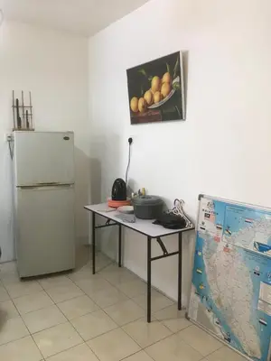 a kitchen with a table and a refrigerator at Batu Kawan Home in Simpang Ampat