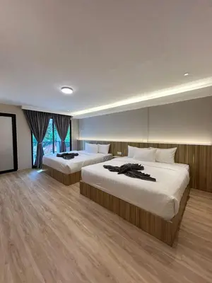 a hotel room with two beds and a television at Alva Boutique Chalet Pangkor in Pangkor