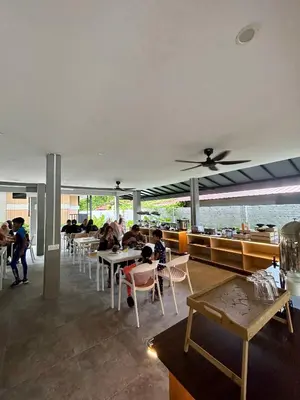 a restaurant with tables and people sitting at tables at Alva Boutique Chalet Pangkor in Pangkor
