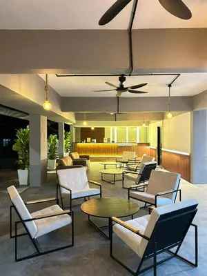 a lobby with chairs and tables and a surfboard on the ceiling at Alva Boutique Chalet Pangkor in Pangkor