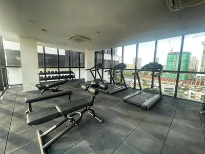 a gym with cardio equipment in a building with windows at Le Petit Suite - 8 Pax Sea View Infinity Pool in George Town