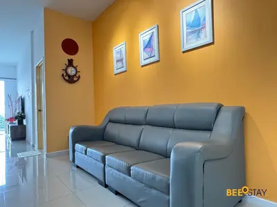 a living room with a couch and a clock on the wall at Taiping Crystal Creek Condo Pool Gym Netflix in Taiping
