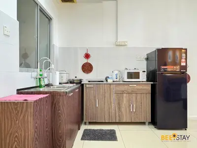 a kitchen with wooden cabinets and a black refrigerator at Taiping Crystal Creek Condo Pool Gym Netflix in Taiping