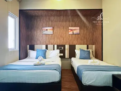 two beds in a hotel room with blue pillows at Seaview Maritime Suites, Penang George Town, Karpal Singh Drive-Free Parking by The Stay Hub in George Town