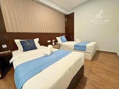 a hotel room with two beds and a sign on the wall at Seaview Maritime Suites, Penang George Town, Karpal Singh Drive-Free Parking by The Stay Hub in George Town