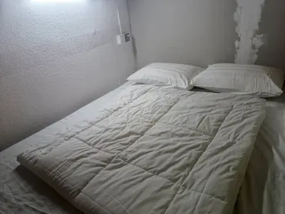 a bed with white sheets and pillows in a room at Cool view budget hotel in Cameron Highlands