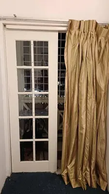 a door with a curtain in front of a window at Cool view budget hotel in Cameron Highlands