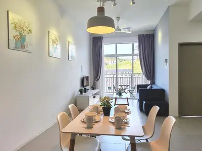 a dining room with a table and chairs and a living room at Family Suite at Cameron Golden Hills in Brinchang
