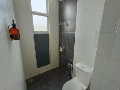 a bathroom with a toilet and a shower with a window at Family Suite at Cameron Golden Hills in Brinchang