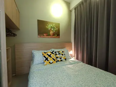 a bedroom with a bed with a blue comforter at Family Suite at Cameron Golden Hills in Brinchang