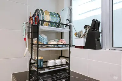 a shelf in a kitchen with dishes and scissors at Family Getaway with Home Comforts Brinchang Cameron Highland Clover Home 2-23A in Brinchang