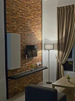 a living room with a tv on a brick wall at b08 The Anderson Ipoh Family Stay 2BR in Ipoh