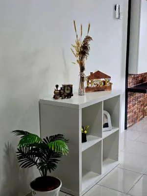 a white cabinet with a plant in a room at b08 The Anderson Ipoh Family Stay 2BR in Ipoh