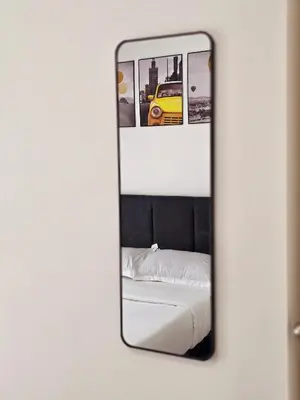 a mirror reflecting a bed and a yellow car at b08 The Anderson Ipoh Family Stay 2BR in Ipoh