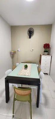 a dining room table with a green table and chairs at TunTeja Homestay in Sungai Petani