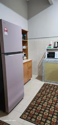 a kitchen with a refrigerator and a stove at TunTeja Homestay in Sungai Petani