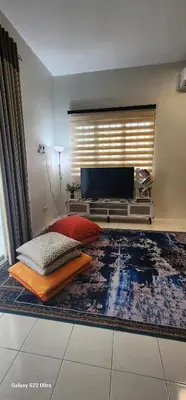 a living room with a bed and a large rug at TunTeja Homestay in Sungai Petani