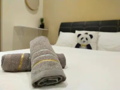 a pile of rolled towels on a bed with a panda bear at 193 Breeze Single Terrace 3BR2B 10pax in Ipoh