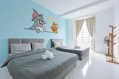 a bedroom with two beds and a blue wall at Tom & Jerry Family Haven with Private Kids Playground Emerald Avenue Brinchang Clover Home 3-16 in Brinchang