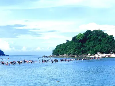 a group of people on a beach in the water at Pangkor Island Pool View Studio 2 Queen Beds 2 Min Walk to the Beach Free WiFi & Parking in Pangkor