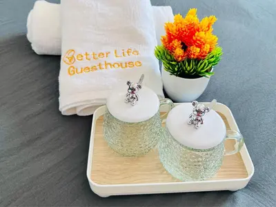 two glass votives on a tray with a vase of flowers at Pangkor Island Pool View Studio 2 Queen Beds 2 Min Walk to the Beach Free WiFi & Parking in Pangkor