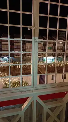 a window with a view of a city at night at Cool view hostel in Tanah Rata