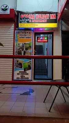 a red bench in front of a building with signs at Cool view hostel in Tanah Rata