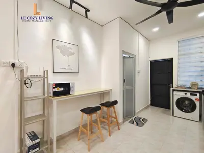 a kitchen with a counter and two stools in a room at The Cozy Retreat House at Bukit Mertajam in Bukit Mertajam