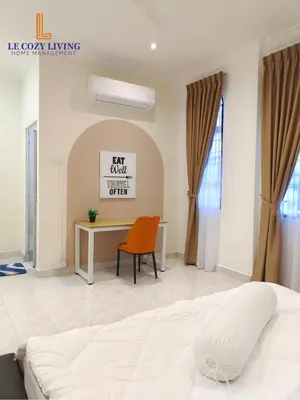 a bedroom with a bed and a desk and a chair at The Cozy Retreat House at Bukit Mertajam in Bukit Mertajam