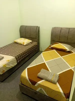 two beds sitting next to each other in a room at Tambun Lastworld Sapari Homestay in Tambun