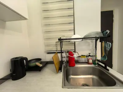 a kitchen with a sink and a shelf above it at Summer Cozy Studio Room in Perai