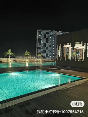 a large swimming pool at night in a city at Summer Cozy Studio Room in Perai