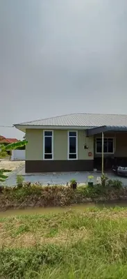 a green house with a car parked in front of it at d'esaku homestay in Penaga