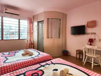a bedroom with a bed and a table and a television at Elephant House Hotel in George Town