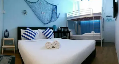 a bedroom with a large white bed and a bunk bed at Elephant House Hotel in George Town