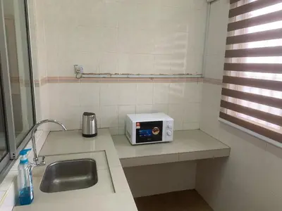 a kitchen counter with a sink and a microwave at TD Homestay in Ipoh