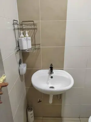 a bathroom with a white sink in a room at Ana Homestay in Seri Manjung