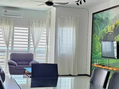 a living room with a couch and a tv at Seaview and 5mins to Paddy Field and Beach in Sekincan